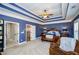 Spacious main bedroom boasts blue walls, a tray ceiling, and a ceiling fan at 2480 Copper Mill Trl, Cumming, GA 30041