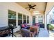 Inviting covered patio featuring comfortable seating, an outdoor grill, and a ceiling fan for added comfort at 2480 Copper Mill Trl, Cumming, GA 30041