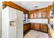 Kitchen with vintage wood cabinets, white refrigerator, and sink next to window at 3160 Ann Se Rd, Smyrna, GA 30080