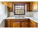 Kitchen sink with double basin and vintage wood cabinets; window view of backyard at 3160 Ann Se Rd, Smyrna, GA 30080