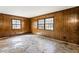 Empty room featuring wood-paneled walls, two windows, and patterned flooring at 3160 Ann Se Rd, Smyrna, GA 30080