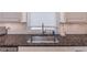 Close-up of the kitchen sink featuring granite countertops and subway tile backsplash at 4162 Gateswalk Se Dr, Smyrna, GA 30080