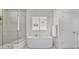 Bright bathroom featuring glass shower, modern tub, and white door at 4535 Atley Woods Se Dr, Atlanta, GA 30339