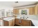 Bright kitchen sink area featuring natural wood cabinets, white countertops and a window view to the exterior at 848 Gateshead Ct, Lawrenceville, GA 30043