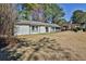 View of a single-story home with a dark garage door, and a lush green lawn, trees in the background at 3915 Basil Sw Way, Atlanta, GA 30331