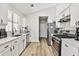 Bright kitchen featuring white cabinets, stainless steel appliances, and wood-look floors at 3915 Basil Sw Way, Atlanta, GA 30331