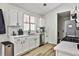 Bright kitchen features white cabinetry, subway tile backsplash, modern appliances, and wood-look floors at 3915 Basil Sw Way, Atlanta, GA 30331