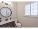 Powder room featuring modern vanity, a round mirror, and plantation shutters at 4055 River Cliff Chase Se, Marietta, GA 30067