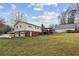 A backyard view showing a two-story home with a garage, back deck and a large green lawn at 2441 Hidden Hills Dr, Marietta, GA 30066