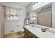 Bathroom featuring single sink, floral wallpaper, and a shower tub combo at 2441 Hidden Hills Dr, Marietta, GA 30066