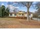 Inviting split-level home with a brick facade, cozy front porch, and beautiful mature trees at 2441 Hidden Hills Dr, Marietta, GA 30066