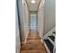 Hallway with wood floors, lots of storage, and leading to stairs at 5550 Mccrossin Cir, Stonecrest, GA 30038
