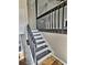 A staircase features dark wood railings and white risers, complemented by wood floors and neutral-colored walls at 5550 Mccrossin Cir, Stonecrest, GA 30038