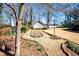 Backyard with a stone walkway, manicured lawn, mature trees and additional buildings at 1341 Longwood Sw Dr, Marietta, GA 30008