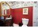 Charming powder room features a dark wood vanity, red walls, and vintage-inspired decor at 1341 Longwood Sw Dr, Marietta, GA 30008