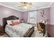 Cozy bedroom with purple walls, a floral bedspread, and a ceiling fan at 1760 Campbell Ives Dr, Lawrenceville, GA 30045