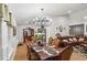 Open concept shows formal dining with modern chandelier and a view to a living room and kitchen at 1760 Campbell Ives Dr, Lawrenceville, GA 30045