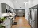 Spacious eat-in kitchen with gray cabinets, stainless appliances, and wood floor open to dining area at 1760 Campbell Ives Dr, Lawrenceville, GA 30045
