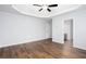 Bedroom featuring a tray ceiling, a ceiling fan, and wood-look flooring at 264 Ascott Ln, Woodstock, GA 30189