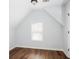 Bedroom featuring a vaulted ceiling, wood-look flooring, and a window with blinds at 264 Ascott Ln, Woodstock, GA 30189