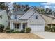 Charming home featuring a brick and shingle facade, well-manicured landscaping, and a two-car garage at 264 Ascott Ln, Woodstock, GA 30189
