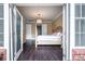 Bedroom view from a porch, showing hardwood floors and a glimpse of the ensuite bathroom at 3280 Stillhouse Se Ln # 101, Atlanta, GA 30339