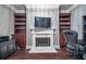 Elegant home office with custom built-ins, a cozy fireplace, and a modern TV at 3280 Stillhouse Se Ln # 101, Atlanta, GA 30339