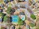 Aerial view of a community pool, tennis courts, mature trees, and surrounding homes at 9390 Knollcrest, Alpharetta, GA 30022
