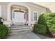 Elegant entryway with a white arched doorway, decorative urns, and an American flag at 9390 Knollcrest, Alpharetta, GA 30022