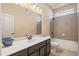 Bathroom featuring single vanity, shower over tub with tile surround at 4930 Cecilia Sq, Cumming, GA 30040