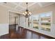 Dining room with hardwood floors, coffered ceilings, chandelier, and large windows offering scenic views at 4930 Cecilia Sq, Cumming, GA 30040