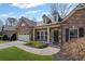 Lovely brick home with two-car garage, manicured lawn, and charming details such as dormer windows at 4930 Cecilia Sq, Cumming, GA 30040