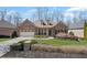 Charming brick home with a well-manicured lawn, complemented by a two-car garage and mature trees at 4930 Cecilia Sq, Cumming, GA 30040