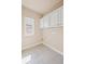 Bright laundry room features white cabinets, tile floors and a window for natural light at 4930 Cecilia Sq, Cumming, GA 30040