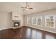 Open living area with hardwood floors, a stone fireplace, and large windows with natural light at 4930 Cecilia Sq, Cumming, GA 30040