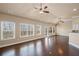 Open living room with expansive windows, hardwood floors, and adjacent kitchen with breakfast bar at 4930 Cecilia Sq, Cumming, GA 30040