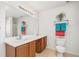Bright bathroom featuring double sinks, white countertops, wooden cabinets and coordinated colorful towels at 5330 Willow Park Blvd, Atlanta, GA 30349