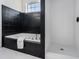 Bathroom featuring a tub with black tile surround and a separate shower with white tiles at 970 Welch Sw St, Atlanta, GA 30310