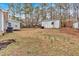 View of the backyard with two outbuildings and large trees at 303 Fireside Trl, Douglasville, GA 30134