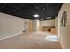Spacious basement with dark ceiling, carpet, tile floor, with a countertop and cabinet area at 303 Fireside Trl, Douglasville, GA 30134