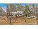 View of the home from the yard showcasing the exterior with mature trees at 303 Fireside Trl, Douglasville, GA 30134