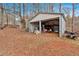 Backyard shed with metal exterior and open garage door, surrounded by fallen leaves at 303 Fireside Trl, Douglasville, GA 30134