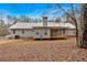 View of the rear of the house showing the covered porch and the surrounding landscape at 303 Fireside Trl, Douglasville, GA 30134