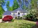 Charming two-story home with a manicured lawn, mature trees, and lush landscaping, creating a welcoming curb appeal at 3304 Woolbridge Ct, Marietta, GA 30062