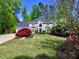 Charming two-story house featuring lush green lawn, mature trees, and colorful landscaping, creating a warm and inviting atmosphere at 3304 Woolbridge Ct, Marietta, GA 30062