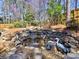 Multi-tiered rock waterfall with decorative statues and water plants in landscaped yard at 3304 Woolbridge Ct, Marietta, GA 30062