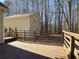 Wooden back deck next to a two-car garage surrounded by trees at 410 Invector Ct, Locust Grove, GA 30248