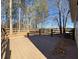 Large wooden back deck with a wooden railing and a wooded backdrop at 410 Invector Ct, Locust Grove, GA 30248