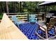 Back deck with Adirondack chairs, a rug, a grill, and surrounding woods at 410 Invector Ct, Locust Grove, GA 30248