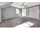 A bedroom with neutral walls, plush carpet, bright windows, and closet space that is ideal for comfortable living at 410 Invector Ct, Locust Grove, GA 30248